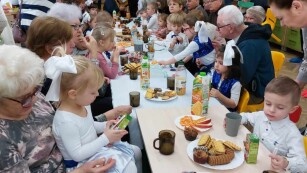 Dzieci i dziadkowie jedzą przy stole