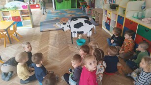 Dzieci oglądają krowę z kartonu