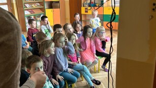dzieci oglądaja edukacyjny filmik na tablicy multimedialnej