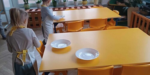 Dzieci rozkładają talerze